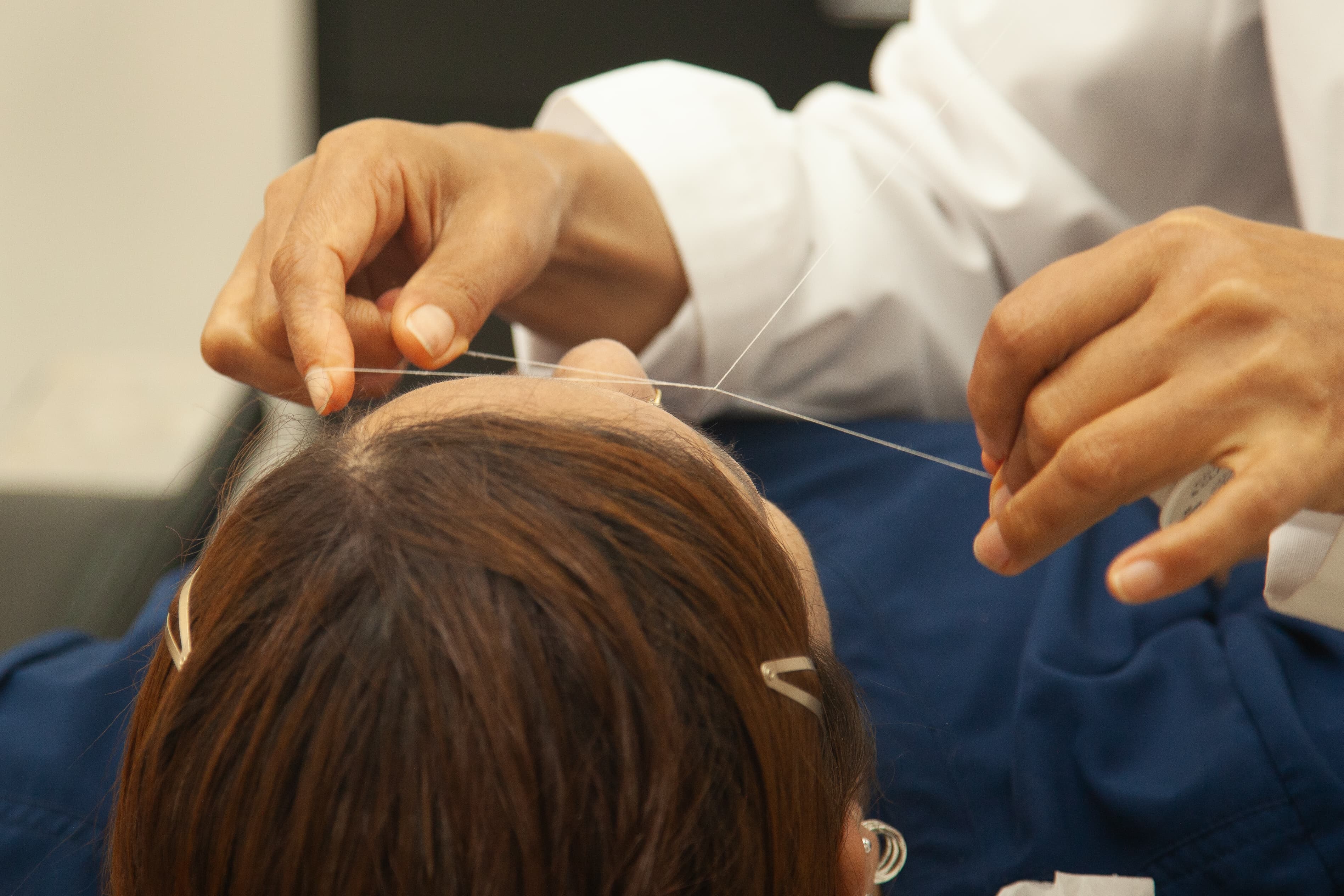 Eyebrow threading hands close-up